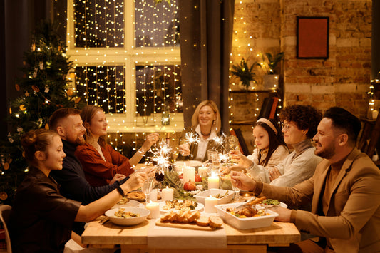 A festive family dinner with kosher meat, candles, delicious dishes, sparklers, and twinkling lights, creating a warm holiday atmosphere with a decorated Christmas tree in the background.